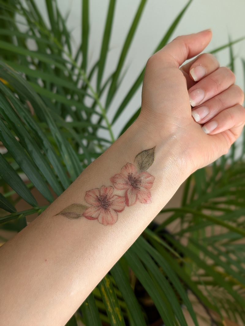 Tatouage fleurs de cerisier couleur au poignet