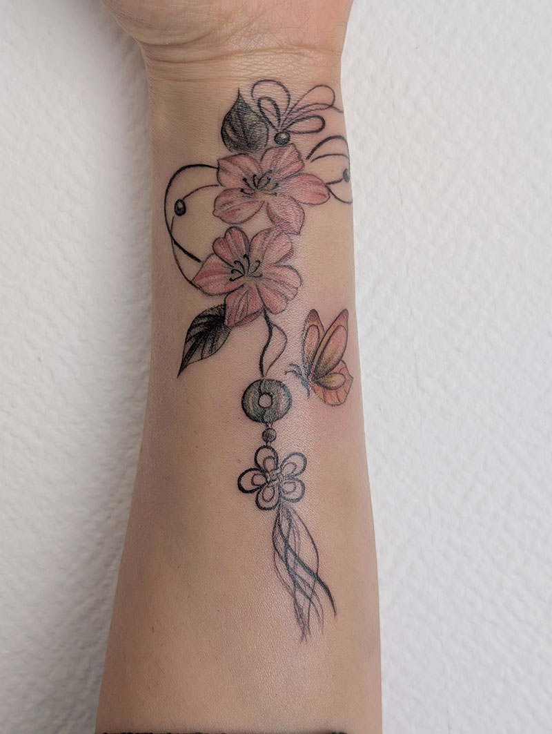 Tatouage fleurs et ornements couleur sur l'avant-bras