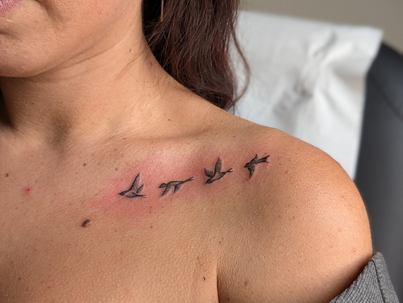 Tatouage fine line oiseaux en vol sur la clavicule